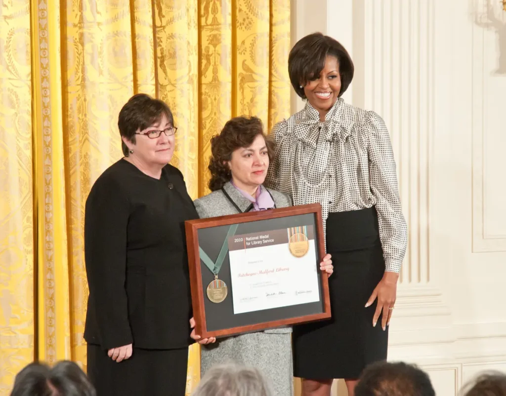 Dina Chrils accepting the National Medal for Museum and Library Service in 2011 from Michele Obama.
