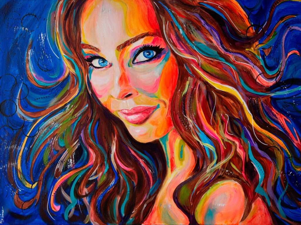 Color portrait of a woman with mostly brown hair against a blue background.